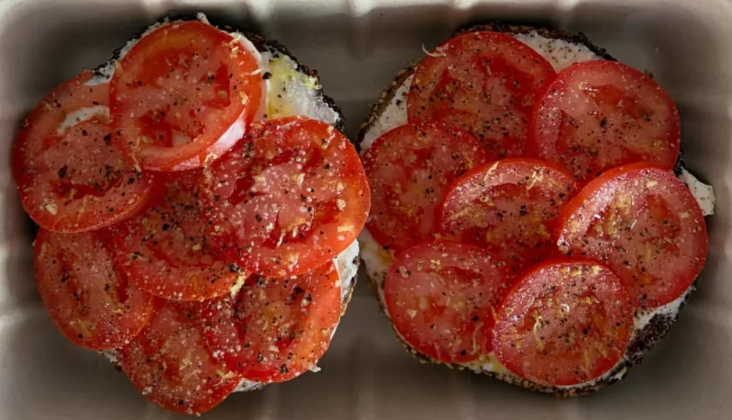 House-baked sesame bagel with cream cheese, tomato, grated lemon and oil